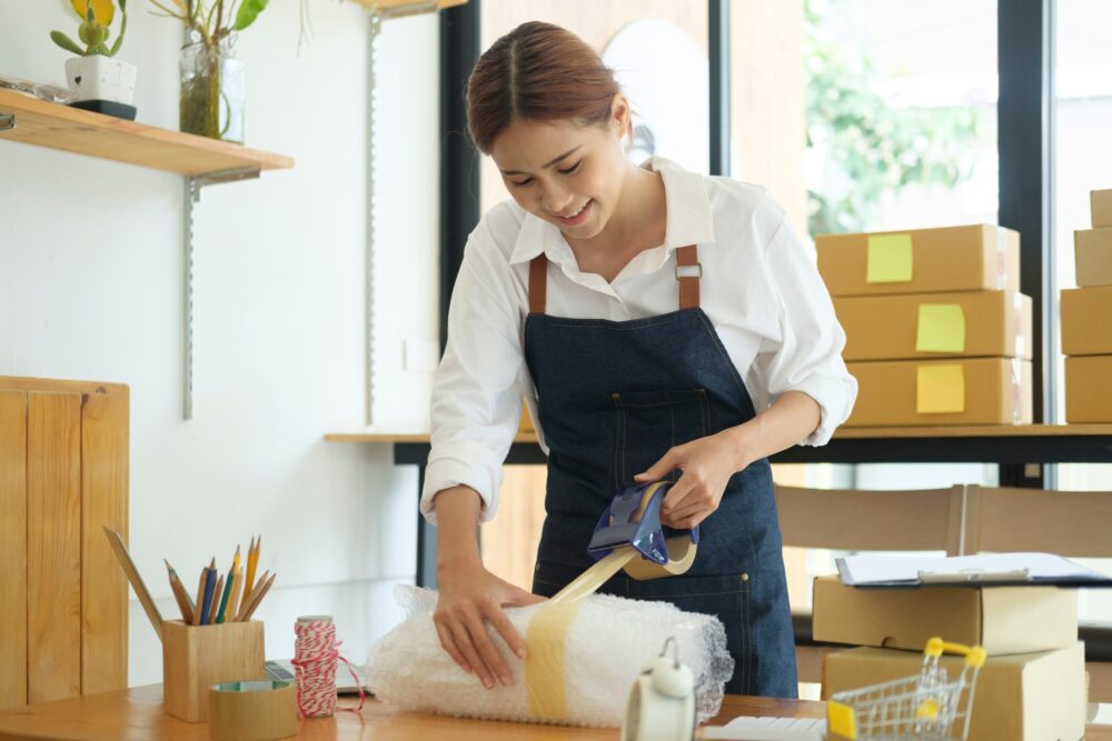 female-online-business-owner-packing-order-box-for-dispatching-